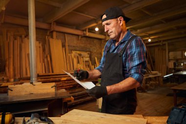 Üst düzey bir marangozun portresi marangozluk atölyesinde mobilya yapmayı planlıyor.