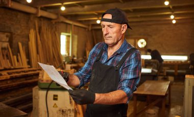 Üst düzey bir marangozun portresi marangozluk atölyesinde mobilya yapmayı planlıyor.