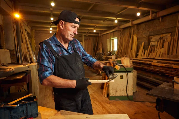 Marangozluk atölyesinde Caliper ile çalışan kıdemli profesyonel marangoz.