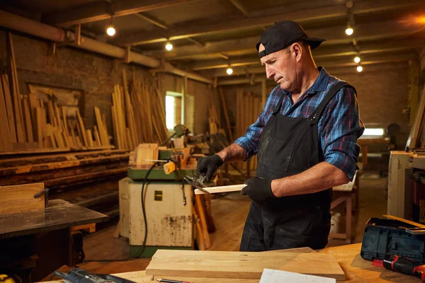 Marangozluk atölyesinde Caliper ile çalışan kıdemli profesyonel marangoz.