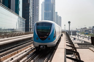 Dubai, Birleşik Arap Emirlikleri - 08 Kasım 2021: Dubai metro treni gökdelenlerin arka planında. Meşhur metro kırmızı hattı.