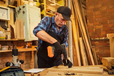 Marangozluk atölyesinde çalışan bir marangozun portresi.