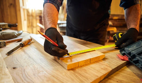 木匠用木头工作 用铅笔标出木板 测量木头的尺寸 在木工车间里做家具 近距离观察 — 图库照片