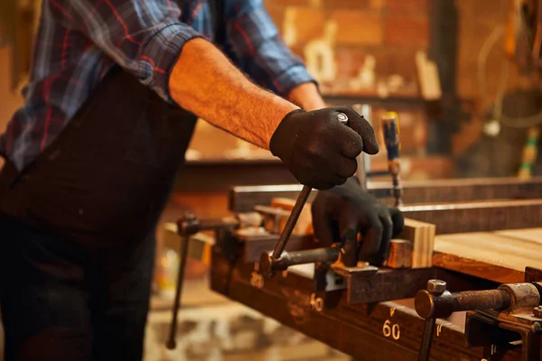 大工製造時の手の圧力と均一な接着木製の棒のシニア大工の肖像画 — ストック写真