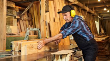 Üniformalı kıdemli marangoz marangozluk fabrikasında marangoz olarak çalışıyor.