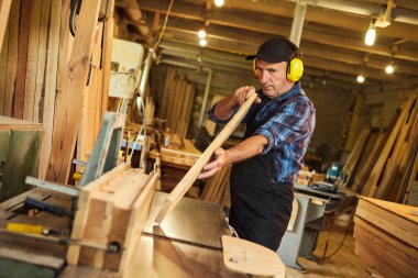 Üniformalı kıdemli marangoz marangozluk fabrikasında marangoz olarak çalışıyor.