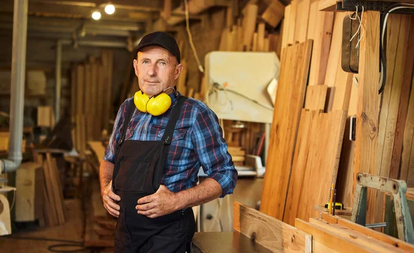 Üniformalı marangozun portresi marangozluk fabrikasında marangozluk yapıyor.