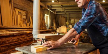 Üniformalı kıdemli marangoz marangozluk fabrikasında marangoz olarak çalışıyor.