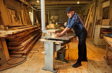 Üniformalı kıdemli marangoz marangozluk fabrikasında marangoz olarak çalışıyor.