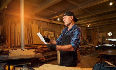 Üst düzey bir marangozun portresi marangozluk atölyesinde mobilya yapmayı planlıyor.