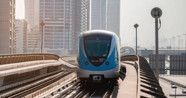 Dubai, Birleşik Arap Emirlikleri - 08 Kasım 2021: Dubai metro treni gökdelenlerin arka planında. Meşhur metro kırmızı hattı.