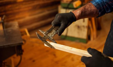 Marangozluk atölyesinde Caliper ile çalışan kıdemli profesyonel marangoz. Kapat.