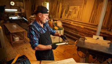 Marangozluk atölyesinde Caliper ile çalışan kıdemli profesyonel marangoz.