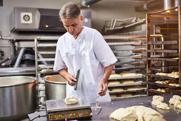 Umiejętny Piekarz Dzieli Surowe Ciasto Równe Porcje Waży Proces Pieczenia — Zdjęcie stockowe