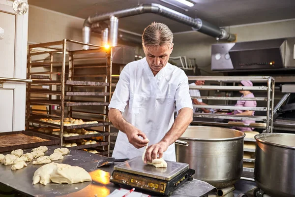 Umiejętny Piekarz Dzieli Surowe Ciasto Równe Porcje Waży Proces Pieczenia — Zdjęcie stockowe