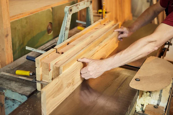 木匠制造业的木工机器上穿着制服工作的高级木匠的近身工作 — 图库照片