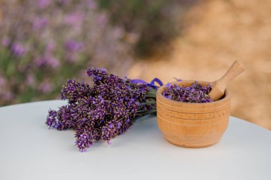 Ahşap kase ve arka planda kurutulmuş lavanta. Çiçekli bitki çayı içeceği. Aromaterapi, ilaç malzemesi. Sakinleştirici içecek.