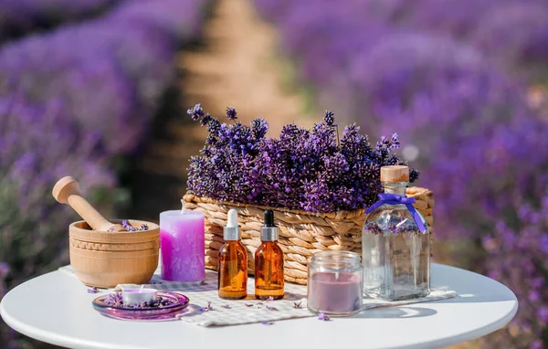 Dropper bottle with lavender cosmetic oil or hydrolate against lavender flowers field as background with copy space. Herbal cosmetics and modern apothecary concept