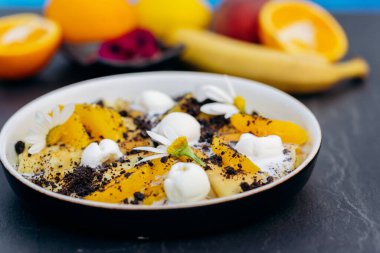 Beyaz tabakta servis edilen dondurmalı, çikolatalı ve portakallı krepler. Sağlıklı ve lezzetli bir kahvaltı.