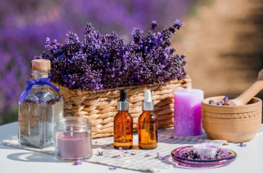 Lavanta kozmetik yağlı damlacık şişesi ya da arka planda fotokopi alanı olarak lavanta çiçekleri tarlasına karşı hidrolat. Bitkisel kozmetik ve modern eczacılık konsepti
