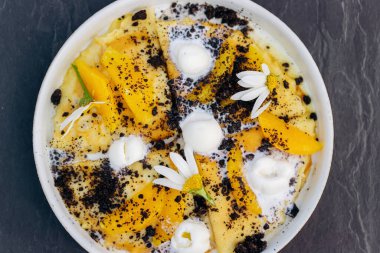 Beyaz tabakta servis edilen dondurmalı, çikolatalı ve portakallı krepler. Sağlıklı ve lezzetli bir kahvaltı.