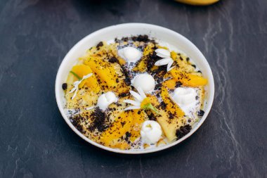 Sweet pancakes with ice cream, chocolate and orange served on white plate. Healthy and tasty breakfast