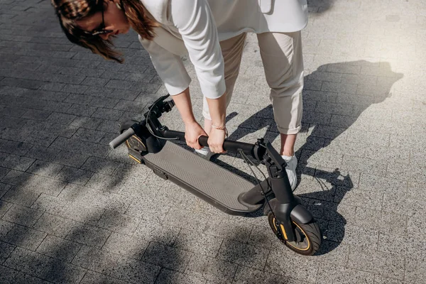 Close Woman White Suit Folding Her Electro Scooter Ride While — 스톡 사진