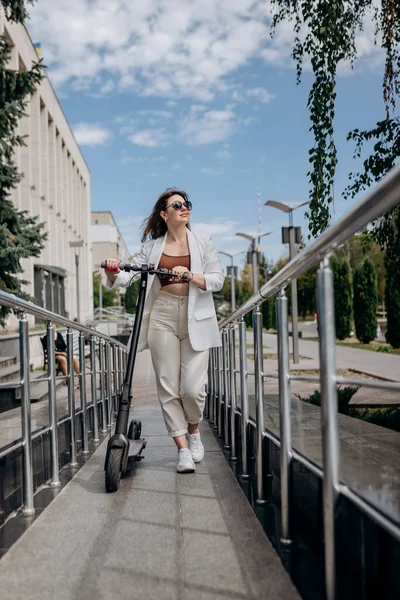 Beautiful Young Woman Sunglasses White Suit Walking Her Electric Scooter — Foto de Stock