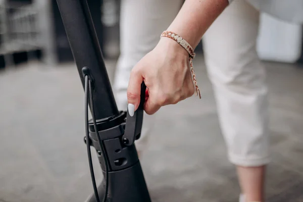 Close Woman White Suit Folding Her Electro Scooter Ride While — 스톡 사진