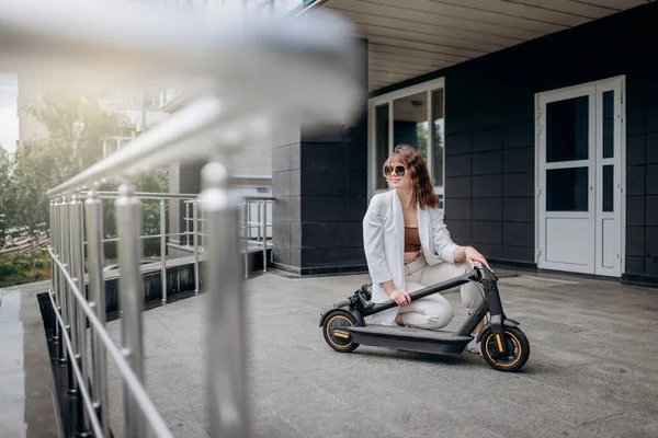 Pretty Woman White Suit Folding Her Electro Scooter Ride While — Fotografia de Stock