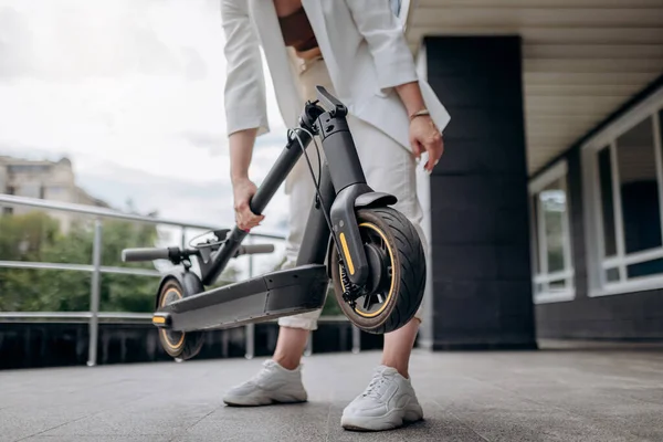 Close Woman White Suit Folding Her Electro Scooter Ride While — 스톡 사진