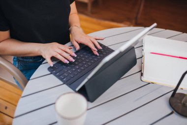 Happy Woman freelancer using a laptop on a cozy glamping tent in a sunny day. Luxury camping tent for outdoor summer holiday and vacation. Lifestyle concept
