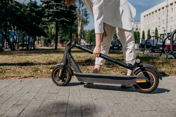 Close Woman White Suit Folding Her Electro Scooter Ride While — Stock Fotó