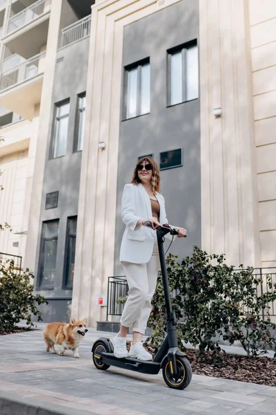 Beautiful Young Woman Sunglasses White Suit Riding Her Electric Scooter —  Fotos de Stock