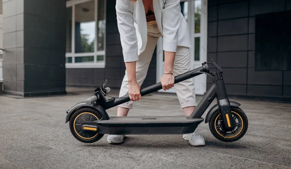 Close Woman White Suit Folding Her Electro Scooter Ride While — Stock Fotó