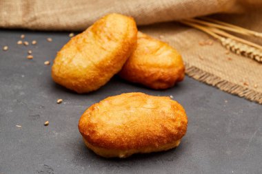 Koyu taşlı arka planda lezzetli kızarmış donutlar. Sağlıksız yiyecekler. Stüdyo çekimi