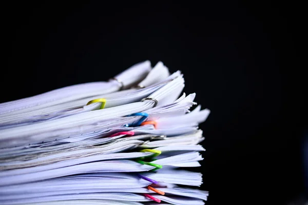 Multicolored paper clips on stack of paperwork — Stockfoto