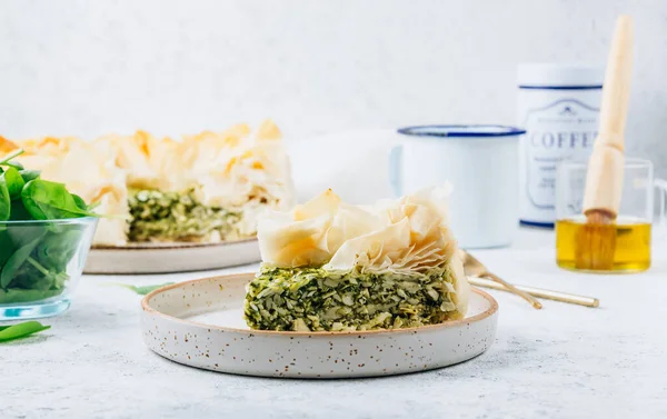Vegetarian spinach pie with feta cheese on white background. Traditional Greek spinach pie Spanakopita