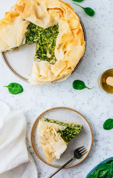 Vegetarian spinach pie with feta cheese on white background. Traditional Greek spinach pie Spanakopita