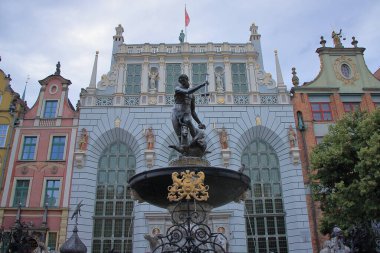 Gdansk (Polonya) - 17. yüzyılın ilk yarısından kalma Neptün heykeli olan bir rokoko çeşmesi ile 15. yüzyıldan kalma Gotik Artus Court 'un arka planına karşı, eskiden tüccarlar için bir buluşma yeri, bir sosyal yaşam merkezi olan