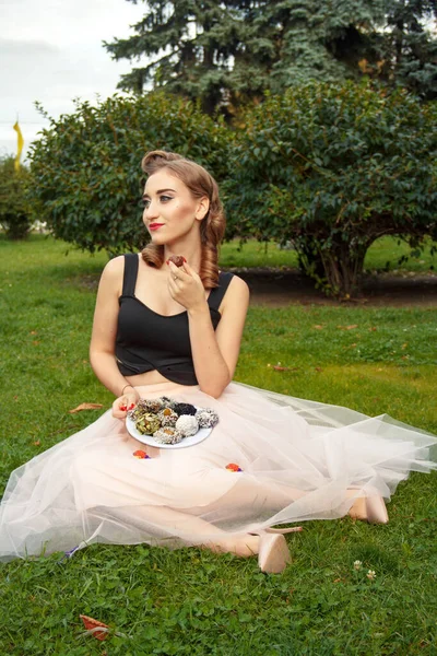 photo session of a pin-up girl in nature eating candy