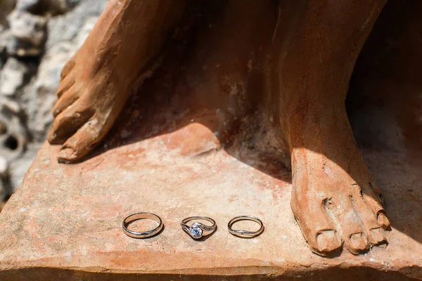 Drei Eheringe auf einer Steinstatue — Stockfoto