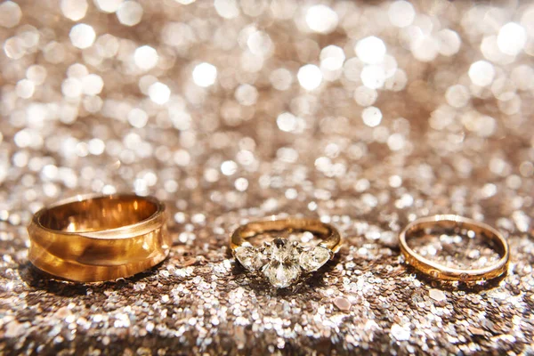 Three wedding ring on a shiny background — Stockfoto