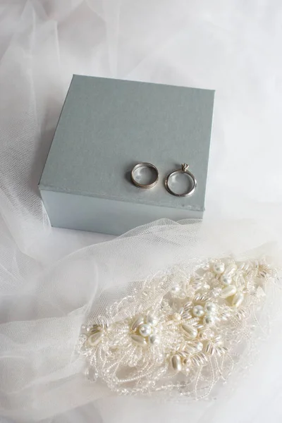 Dva snubní prsteny a krabice na závoji — Stock fotografie