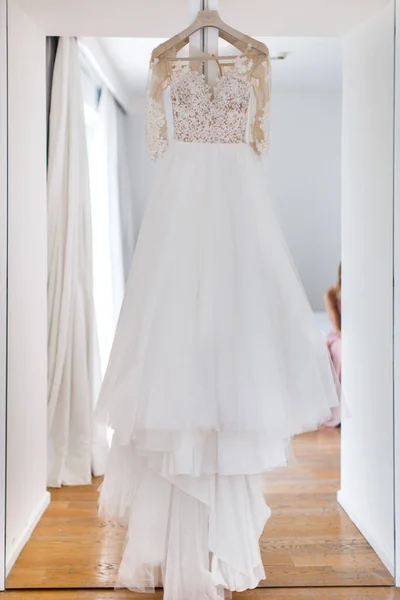 Esküvői ruha lógott az ajtón, fehér a helyiségben — Stock Fotó