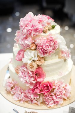 Renkli çiçeklerle süslenmiş çok katlı düğün pastası..