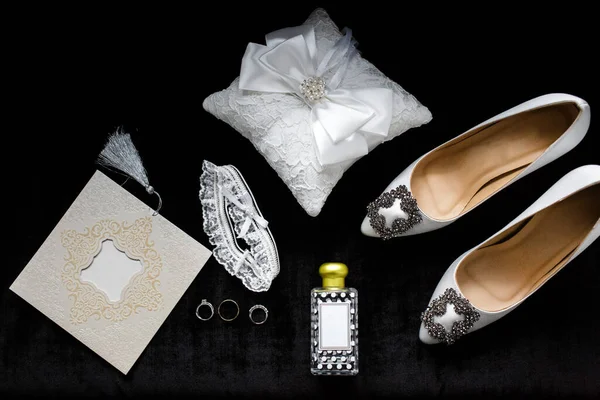 Wedding shoes and accessories on a black background.