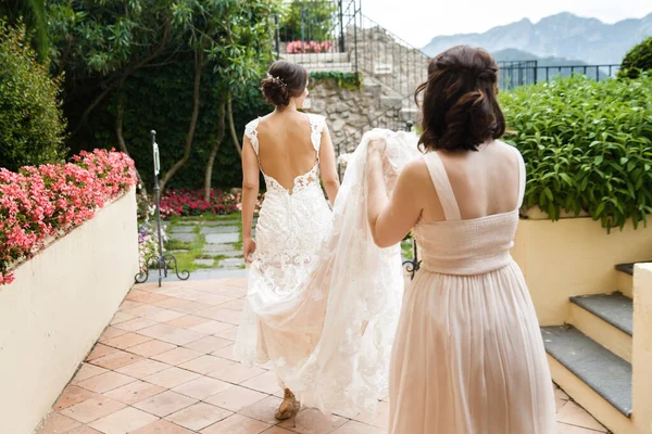 Bridesmaid Helps Bride Hold Dress — Stockfoto
