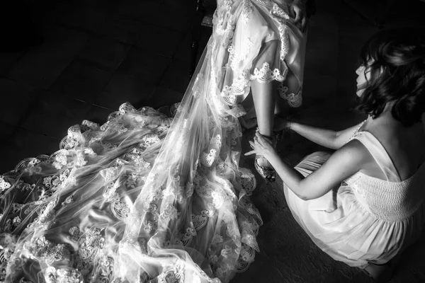 Nedime, gelinin ayakkabılarını giymesine yardım ediyor..