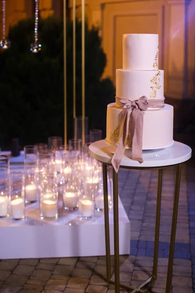 Mehrstöckige Hochzeitstorte Auf Dem Hintergrund Von Kerzen — Stockfoto